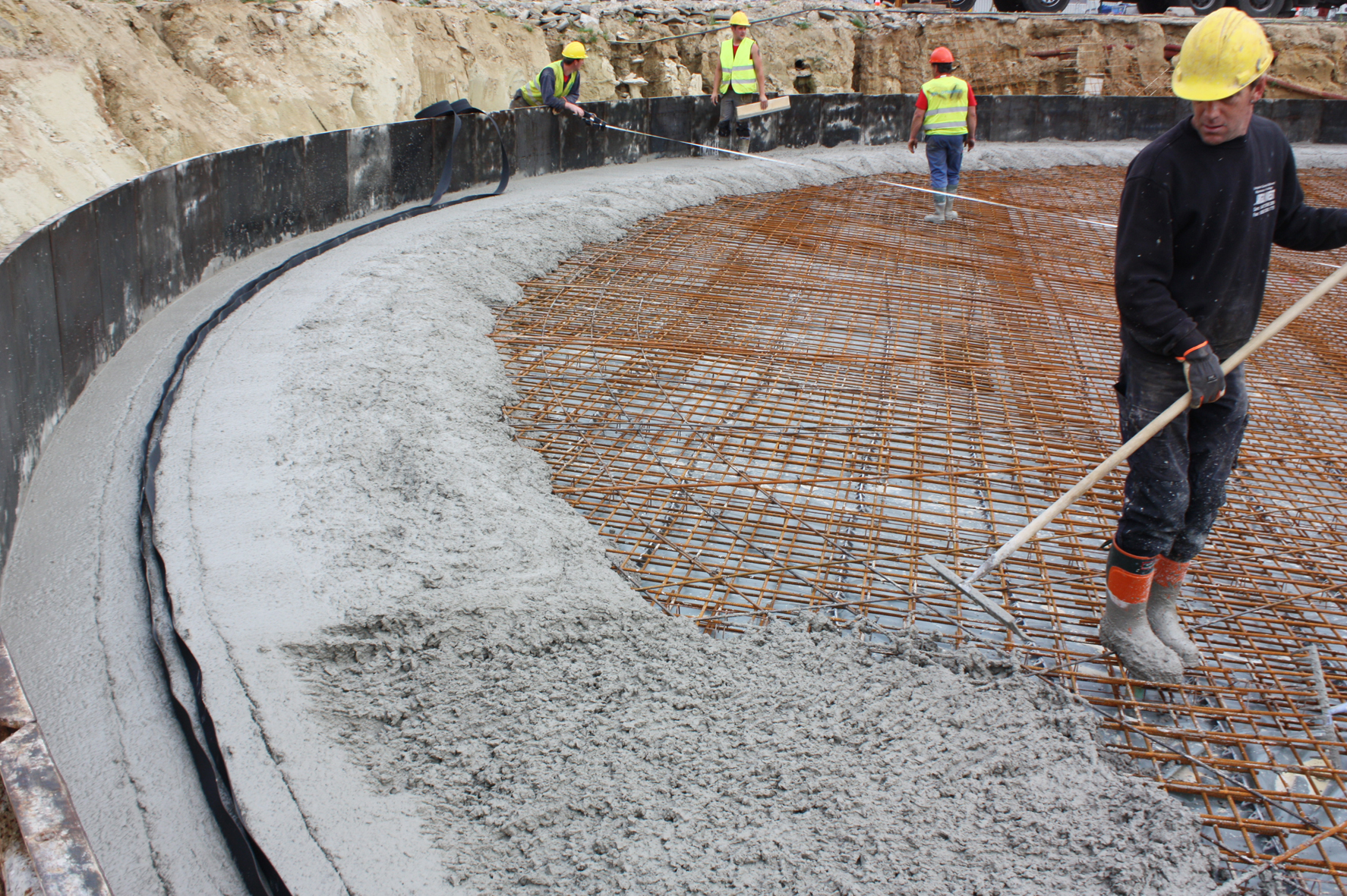 Wapening en beton voor de vloer van een ter plaatse gestorte tank, binnen de reeds gestorte wand