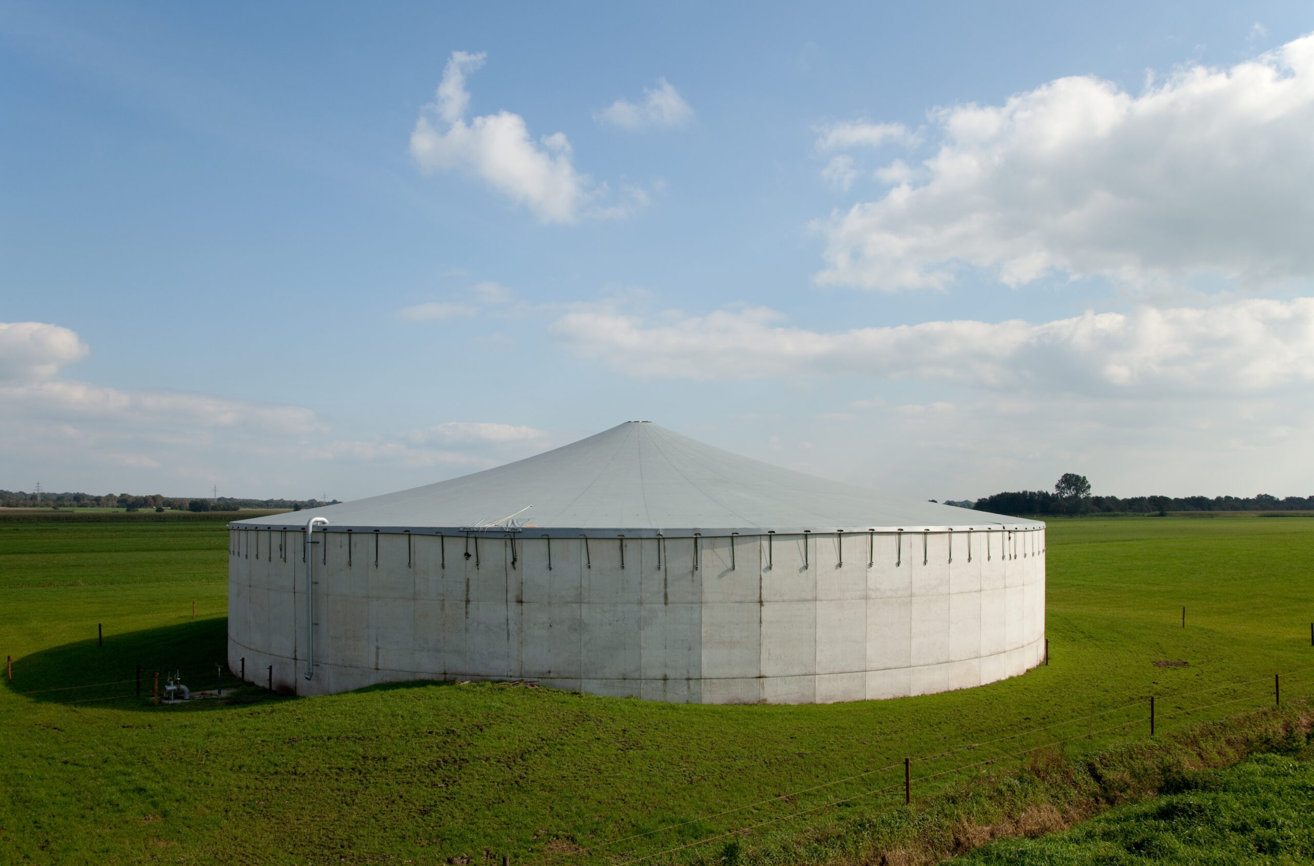 Ronde betonnen mestsilo van Monostore met afdekking, in een weiland